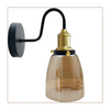 Lifestyle shot of the Whitechapel wall sconce in a contemporary bedroom, accentuating its warm glow and stylish brass finish
