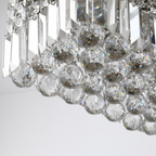 Vela chandelier in a luxurious setting, highlighting its contemporary design and sparkling crystal details
