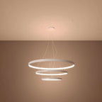 Side view of the Rio tiered LED halo pendant chandelier in a stylish living room setting, demonstrating its elegant presence