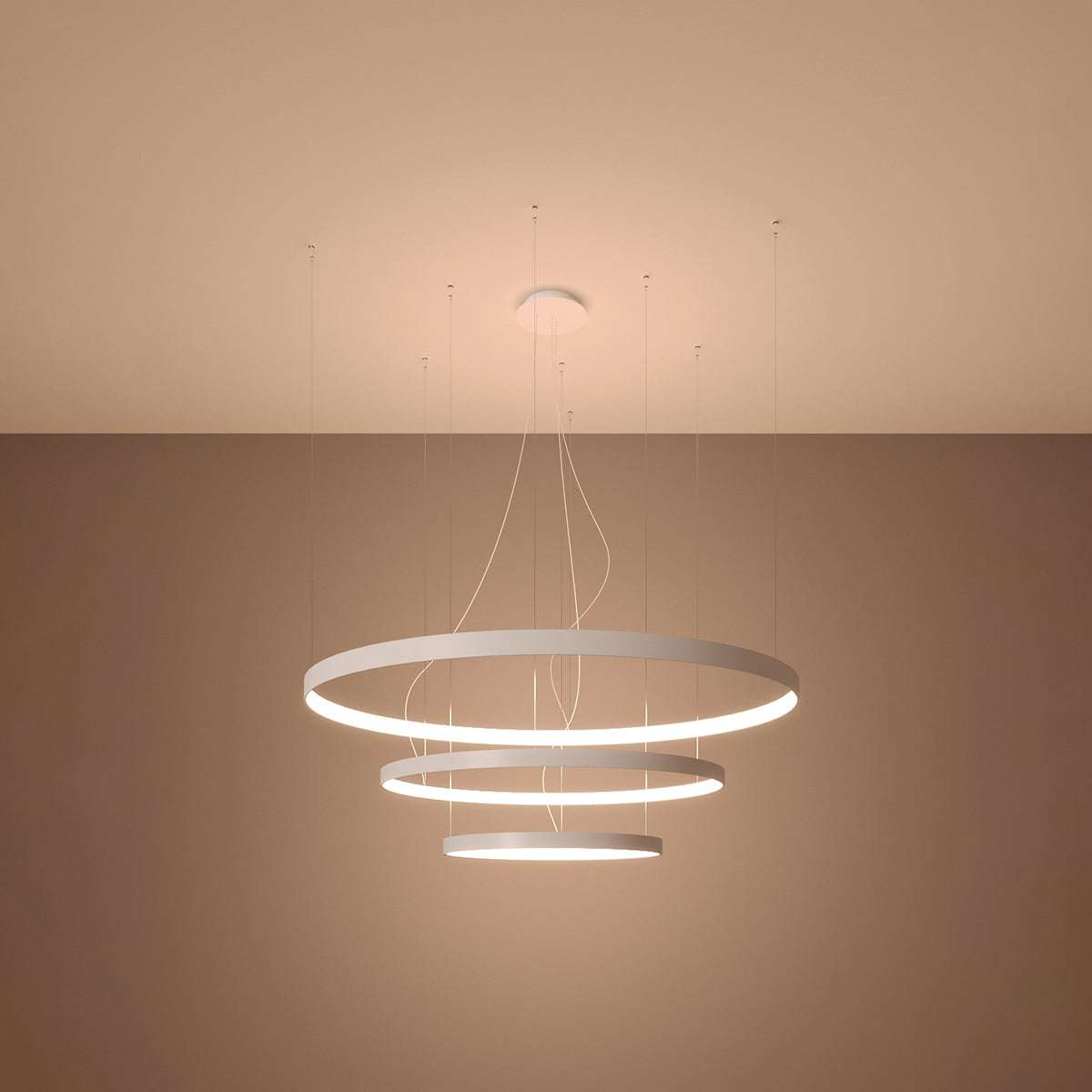Side view of the Rio tiered LED halo pendant chandelier in a stylish living room setting, demonstrating its elegant presence