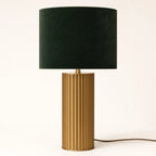 Albany fluted brass touch table lamp on a soft warm-white background — full product view of the brushed brass column with vertical fluting beneath a deep forest-green velvet drum shade