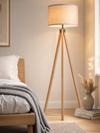 Highgate wood tripod floor lamp casting soft light in a minimal, serene bedroom corner
