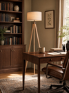 Highgate tripod floor lamp providing warm light beside a walnut desk in a refined home study