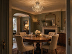 Lyra petite round crystal chandelier in a sage-green Georgian dining nook with round oak table and marble fireplace