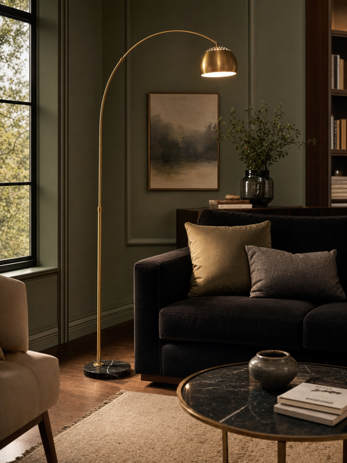 Mayfair brass arc floor lamp in a refined living room with dark velvet sofa and sage green walls