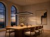 Meridian rectangular halo LED pendant chandelier above a long oak dining table at twilight
