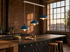 Shoreditch 3-light industrial dome bar pendant in petrol blue, suspended over a soapstone kitchen island in a warehouse-conversion loft kitchen with exposed brick and Crittall windows