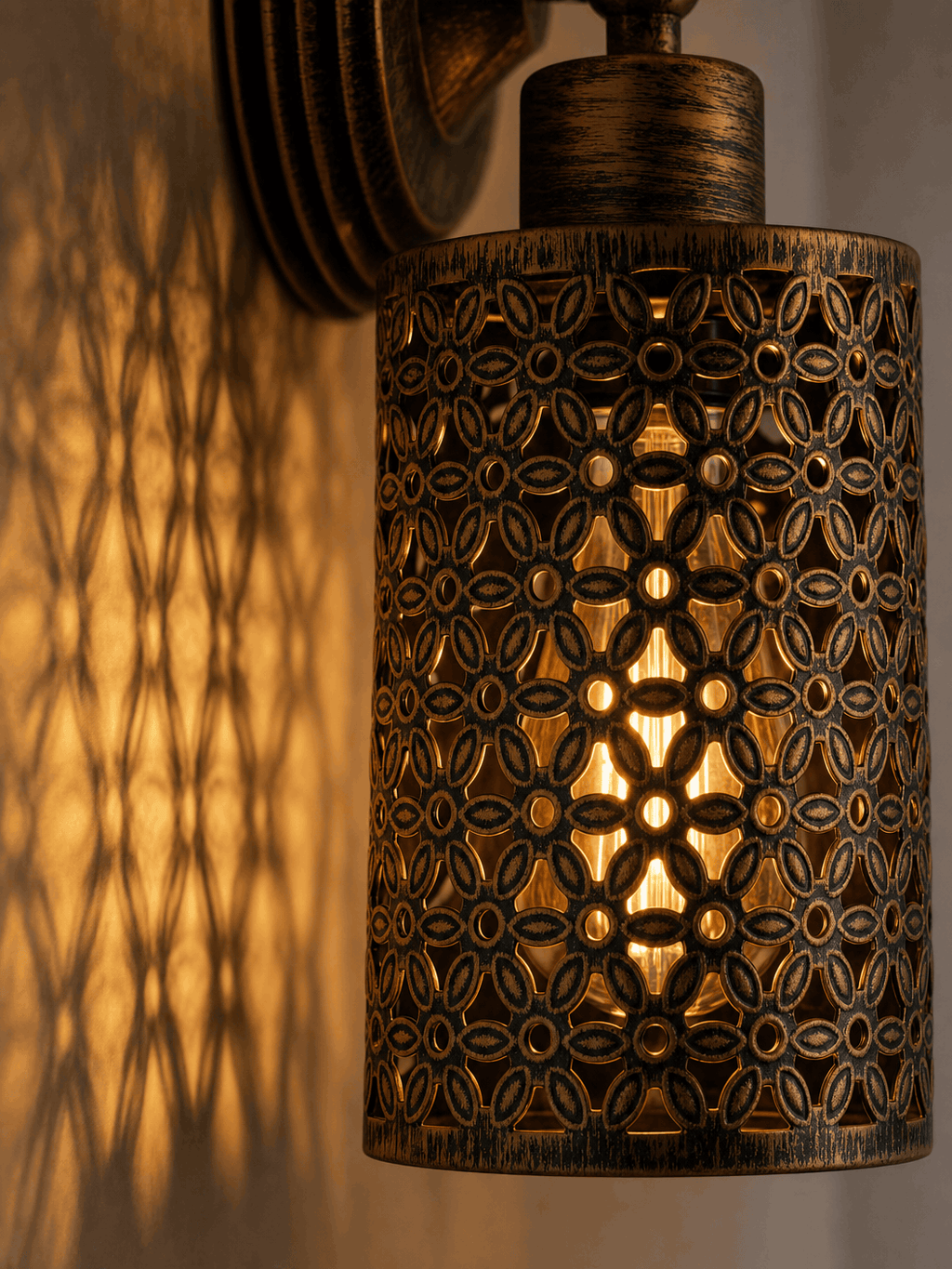 Close-up detail of the Spitalfields wall sconce showing ornate perforated floral metalwork and warm amber light patterns