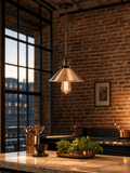 Wapping copper cone pendant light hanging above a marble kitchen island in an industrial warehouse